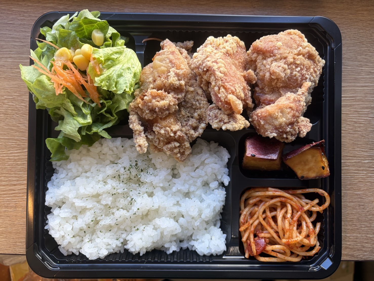 唐揚げ、ご飯、サラダの入ったお弁当